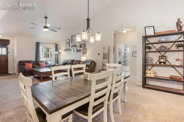 carpeted dining space featuring high vaulted ceiling and ceiling fan