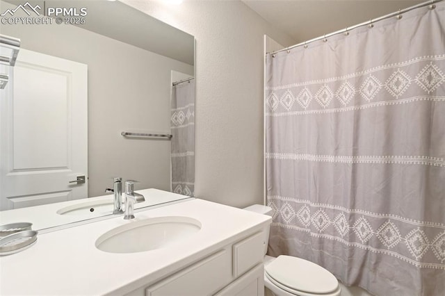 bathroom featuring vanity, curtained shower, and toilet