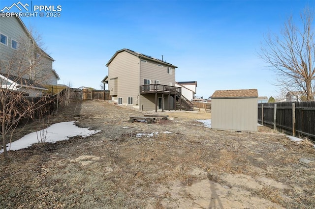 rear view of property with a deck and a shed