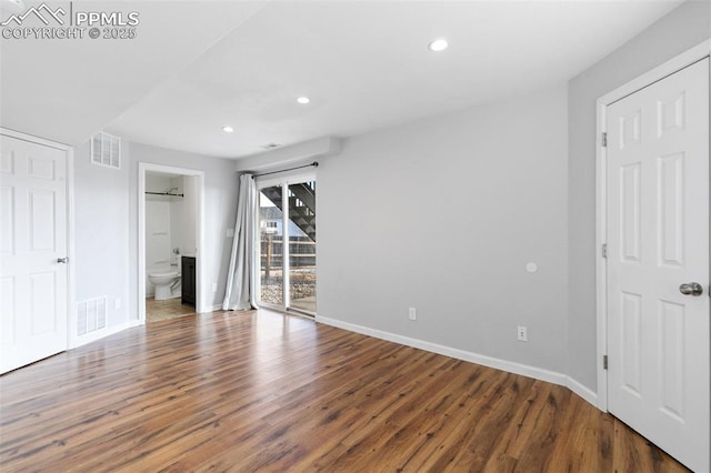 unfurnished bedroom featuring connected bathroom, access to exterior, and wood-type flooring