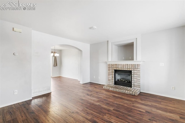 unfurnished living room featuring a fireplace and dark hardwood / wood-style flooring