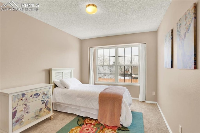 bedroom with light colored carpet and a textured ceiling