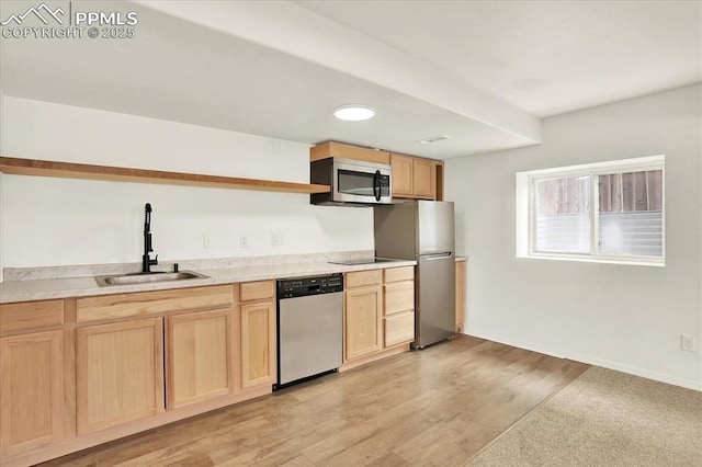 kitchen with stainless steel appliances, light brown cabinetry, sink, and light wood-type flooring