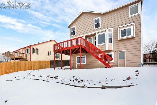 snow covered rear of property featuring a wooden deck