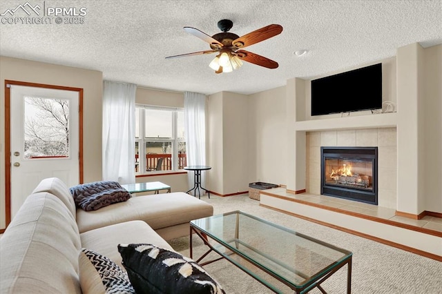 carpeted living room featuring ceiling fan, a textured ceiling, and a fireplace