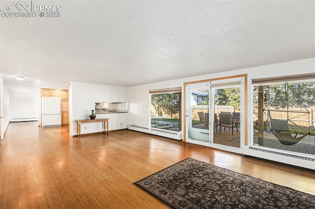 unfurnished living room featuring a baseboard radiator, wood-type flooring, and a textured ceiling