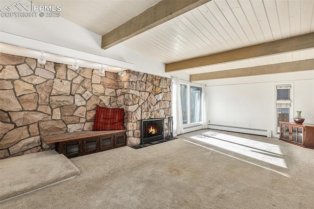 living room with a baseboard heating unit, carpet floors, track lighting, a stone fireplace, and beamed ceiling