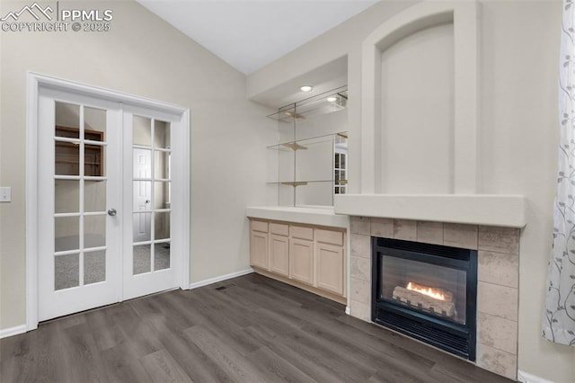 bar with a tiled fireplace, dark wood-type flooring, vaulted ceiling, and french doors