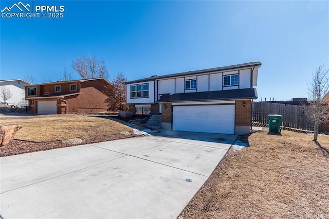 view of front of home featuring driveway, an attached garage, and fence