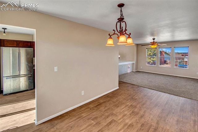 unfurnished room with a ceiling fan, light wood-style flooring, and baseboards