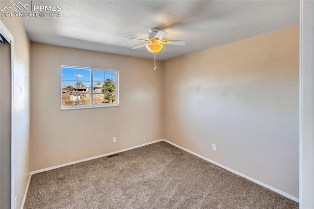 carpeted empty room with a textured ceiling, ceiling fan, visible vents, and baseboards