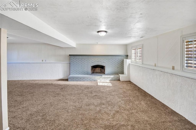 unfurnished living room featuring carpet, a fireplace, and a textured ceiling