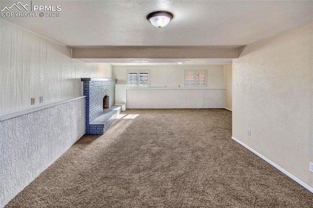 unfurnished living room featuring carpet, a fireplace, and baseboards