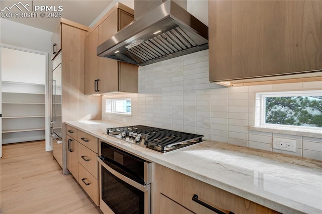 kitchen featuring light hardwood / wood-style flooring, backsplash, stainless steel appliances, extractor fan, and light brown cabinets