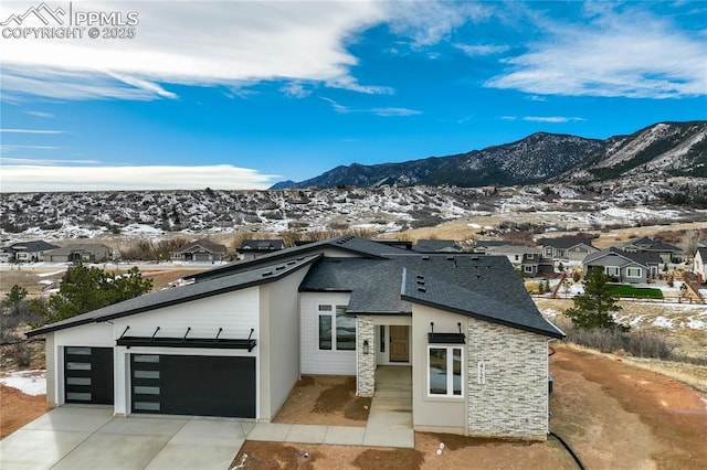 view of front of home with a garage and a mountain view