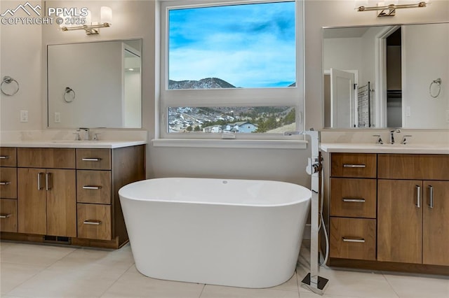 bathroom with vanity, a bath, and tile patterned flooring