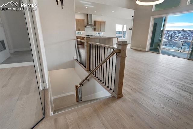 staircase featuring wood-type flooring and sink