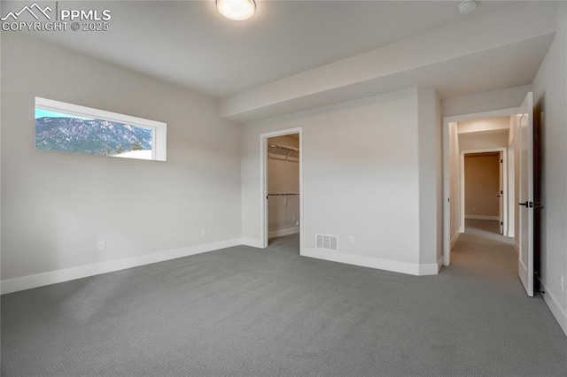 unfurnished bedroom featuring a spacious closet and carpet