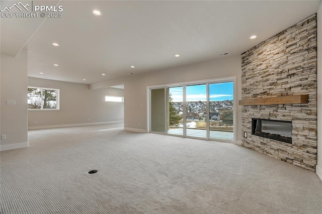 unfurnished living room featuring light carpet and a fireplace