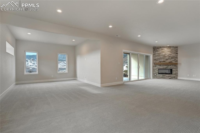 unfurnished living room featuring a fireplace and light colored carpet