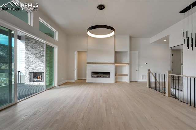 unfurnished living room featuring light wood-type flooring and a fireplace