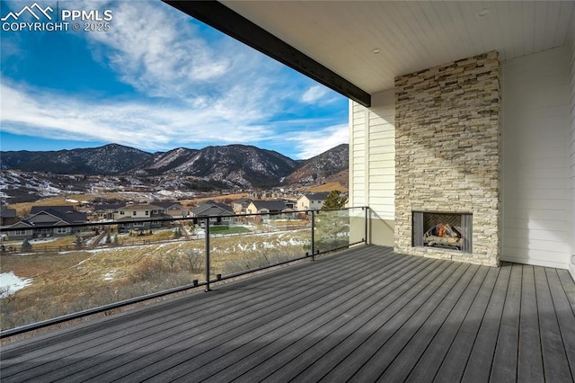 deck featuring a mountain view and an outdoor stone fireplace