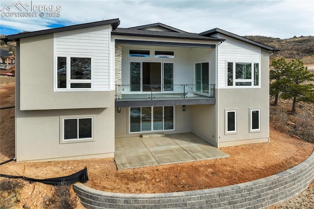 back of house featuring a balcony and a patio area