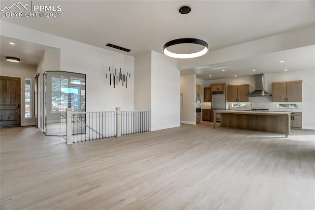 unfurnished living room with sink and light hardwood / wood-style flooring