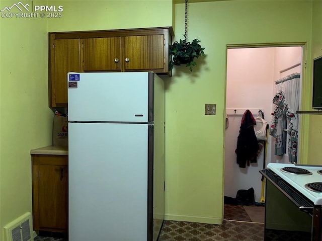 kitchen featuring electric range oven and white fridge