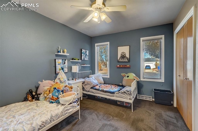 bedroom with ceiling fan, carpet flooring, and a closet