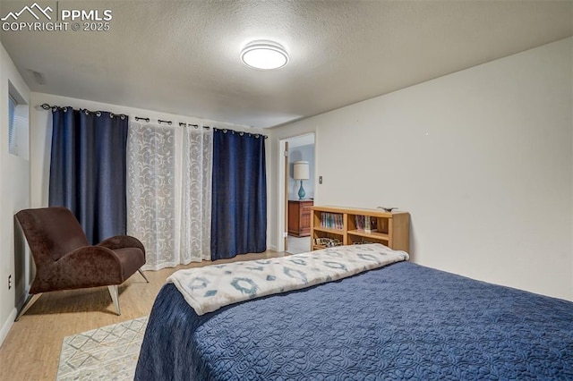 bedroom featuring wood-type flooring and a textured ceiling