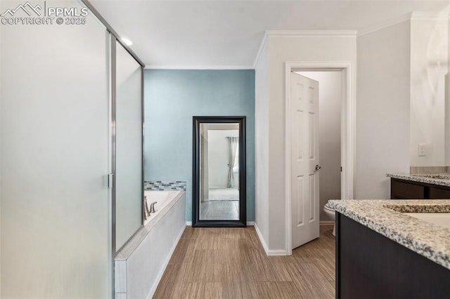 interior space featuring hardwood / wood-style flooring, vanity, crown molding, and independent shower and bath