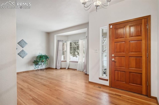 entryway with a notable chandelier and light wood-type flooring