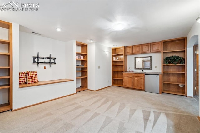 unfurnished living room with built in shelves and light carpet