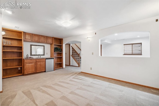 unfurnished living room with sink and light colored carpet