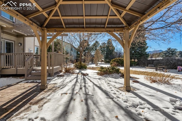 snow covered patio featuring a gazebo and a wooden deck