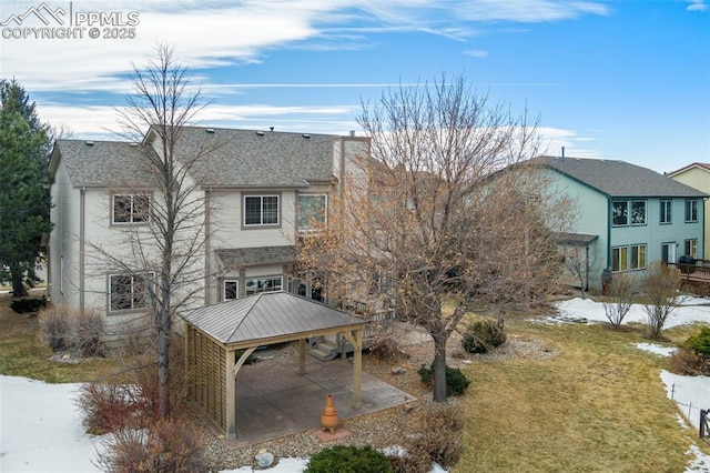 snow covered house featuring a carport and a yard