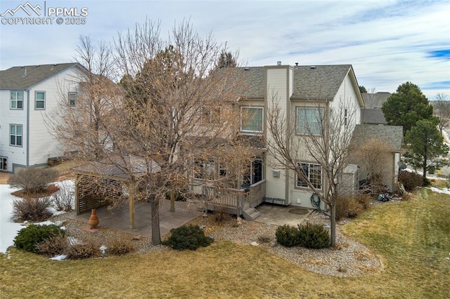 back of property with a wooden deck, a yard, and a patio area