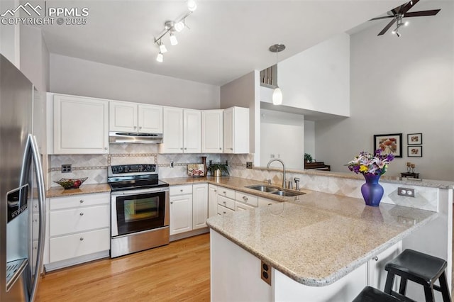 kitchen with hanging light fixtures, sink, kitchen peninsula, and appliances with stainless steel finishes