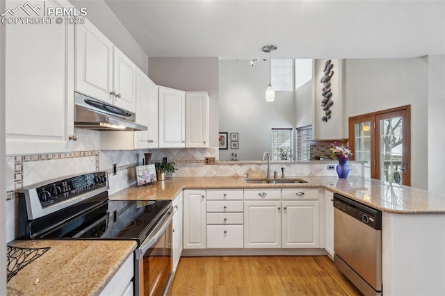 kitchen with sink, white cabinetry, stainless steel appliances, decorative light fixtures, and kitchen peninsula