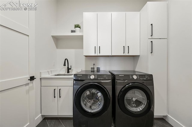 laundry room featuring cabinets, washer and clothes dryer, and sink