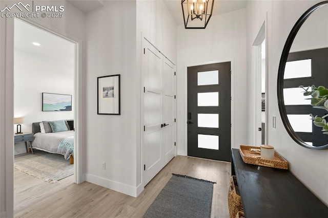 entryway featuring an inviting chandelier and light hardwood / wood-style flooring