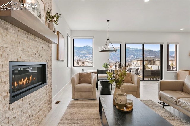 living room featuring a mountain view, a notable chandelier, and light hardwood / wood-style flooring