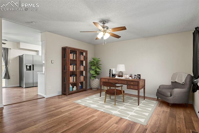 office area featuring ceiling fan, wood-type flooring, and a textured ceiling