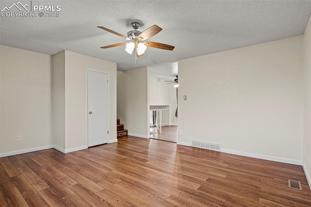 spare room with hardwood / wood-style flooring, ceiling fan, and a textured ceiling