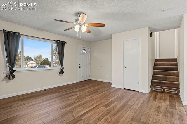 entrance foyer with hardwood / wood-style flooring, a textured ceiling, and ceiling fan