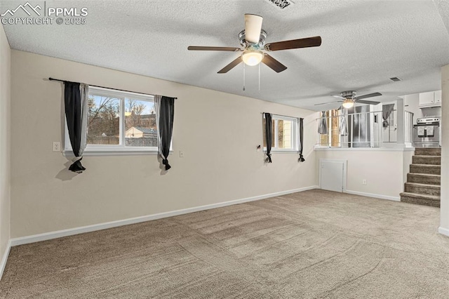 spare room with light carpet and a textured ceiling