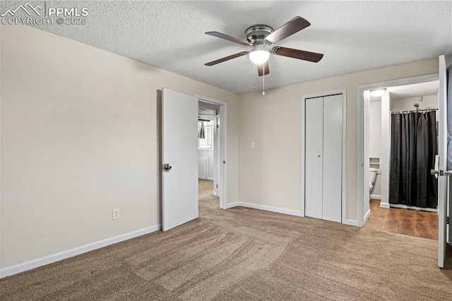 unfurnished bedroom featuring ensuite bath, light colored carpet, a textured ceiling, a closet, and ceiling fan