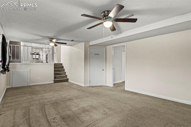 unfurnished living room with ceiling fan, carpet, and a textured ceiling