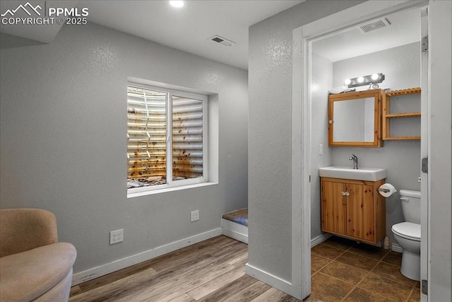 bathroom with vanity, wood-type flooring, and toilet